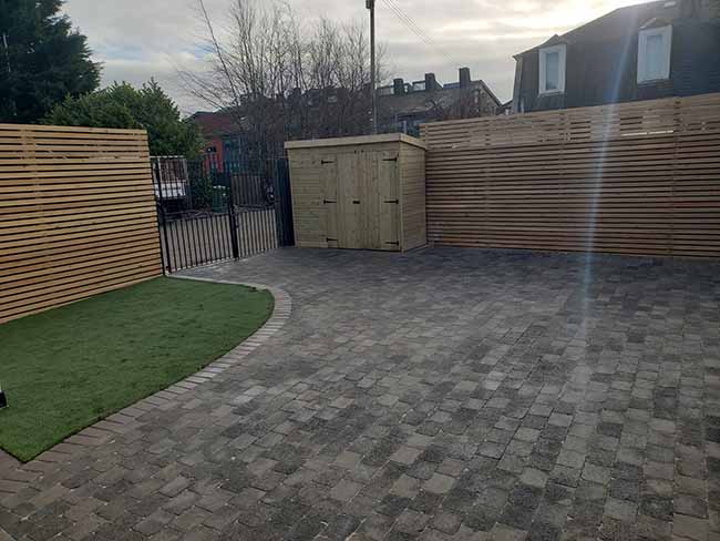 Slate, tumbled tegula block paving with a natural pedesta border in Cathcart.