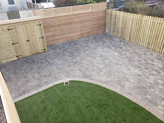Artificial grass was laid while completing slate, tumbled tegula block paving with a natural pedestal border. The fence and tool shed was completed.