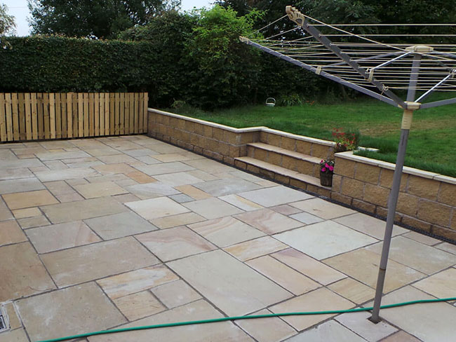 Indian sandstone garden patio with fencing & retaining wall
